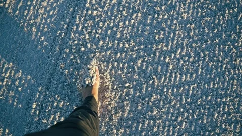 Barefoot person walking on patterned beach sand in sunlight Stock Footage 305648394