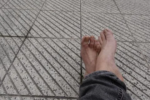 Barefoot relaxing on a patterned pavement during summer vacation Stock Photos