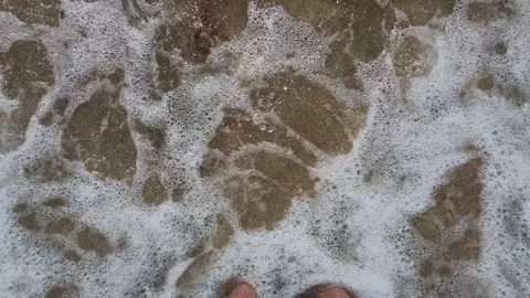 Barefoot standing on wet sandy beach with ocean water Vídeos de archivo 345697876