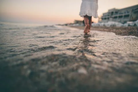 Barefoot Steps Through Shallow Waves at Sunset Stock Photos