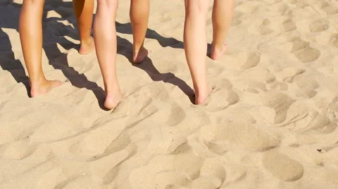 Barefoot walking at beach. Legs of three slender young woman Stock Footage 67349268