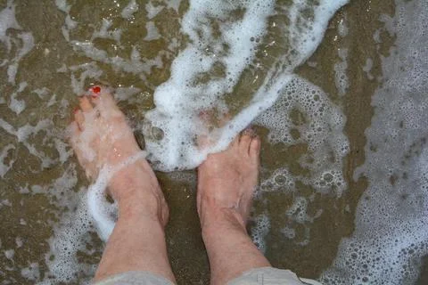 Barefoot in the water by the sea Stock Photos