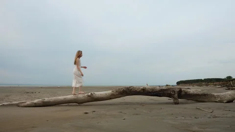 Barefoot Woman Walking on Fallen Tree Along Empty Beach. Stock Footage 346797993