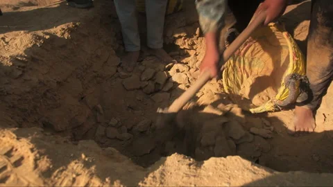 Barefoot worker digging a hole with a pickaxe Stock-Footage 336752846