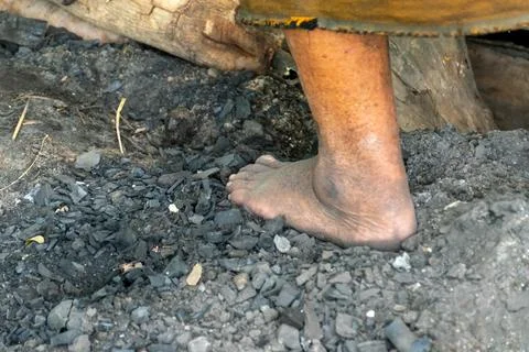 Barefoot Worker Standing on Charcoal Stock Photos