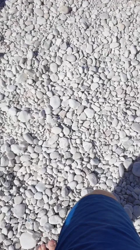 Barefooted man walking by rocky beach Stock Footage 166846852