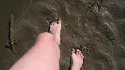 Barefooted man is walking on wet sand on riverbank, closeup feet. Stock Footage 158297201