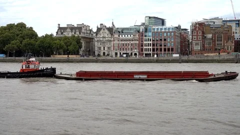 A barge being pushed by a tug along the River Thames in London. Stock Footage 80453381