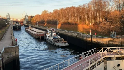 Barge cargo ship stands in the channel to pass through the locks into river Stock Footage 124464188