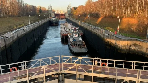 Barge cargo ship stands in the channel to pass through the locks into river Stock Footage 124464219