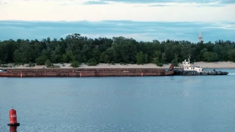 Barge floating on the river along the shore. The red buoy in the foreground Video stock 132277103