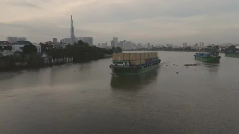 A barge loaded with shipping containers slowly floats down a river Stock Footage 296592874