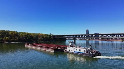 Barge moves along river under bridge in urban area 库存影片 343125874