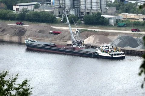 Barge on the river Unloading river sand from a barge Navigable river, river port Stock Photos