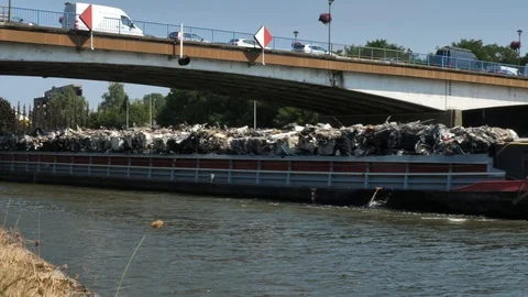 Barge transporting scrap metal under a bridge on a canal Stock Footage 92353728