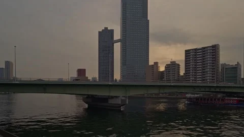 Barge Under Sumida River Bridge at Dusk – Iconic Connected Tower Against Amber Видео 339765143