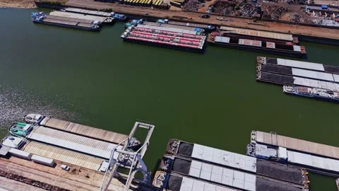 Barges lined up in a storage yard near a waterway in broad daylight Stockbeeldmateriaal 343118517