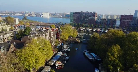 Barges lining a leafy canal that runs out to open water Stock-Footage 71295596
