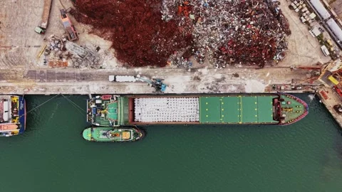 Barges work at a port with a scrap yard and a ship preparing for transport Stock-Footage 338324361