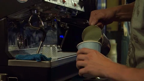 Barista adding milk to latte in the outside bar during late evening Stock Footage 128541664