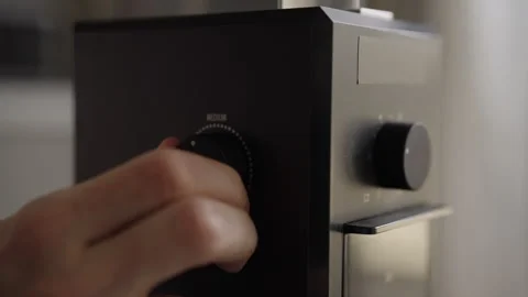 Barista adjusting grind size setting on modern black electric coffee grinder Stock Footage 342754968