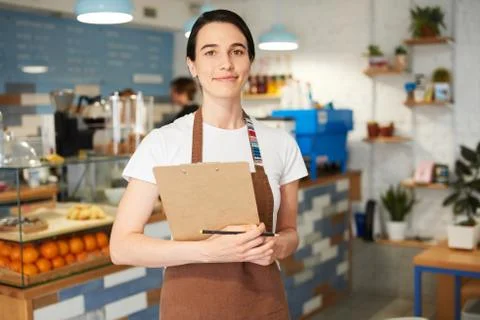 Barista in the apron looking at the camera. Stock Photos
