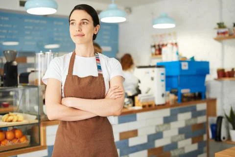 Barista in the apron looking at the camera. Stock Photos