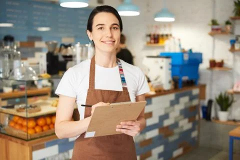 Barista in the apron looking at the camera. Stock Photos