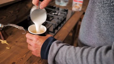 Barista brews coffee in a paper cup and pours whipped cream Stock Footage 201836799
