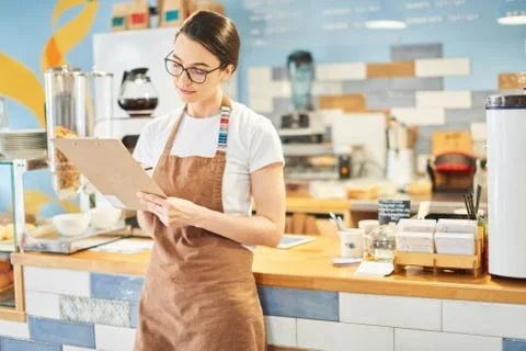 Barista checking the information in the notepad. Stock Photos