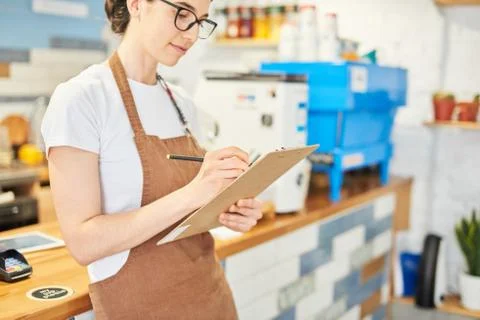 Barista checking the information in the notepad. Stock Photos