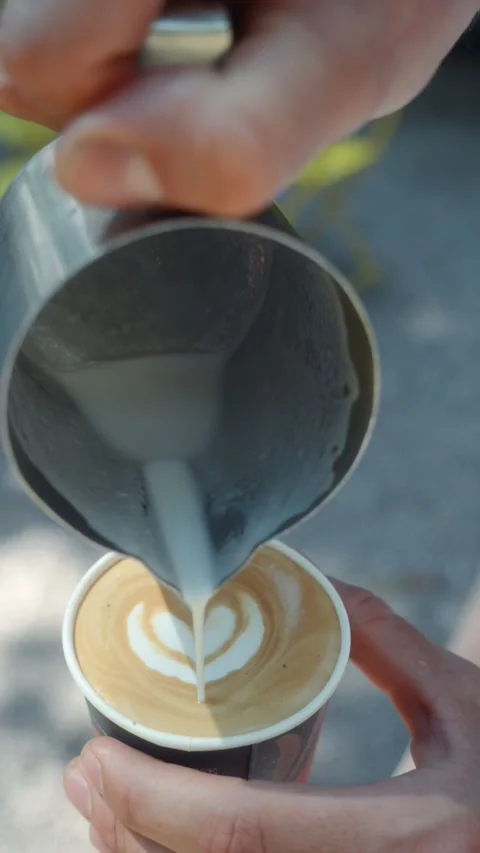 Barista Creating Latte Art Pattern with Steamed Milk in Coffee Stock Footage 339598837