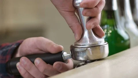 Barista forms a coffee tablet in a holder - behind the bar Stock Footage 77903289