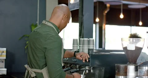 Barista glancing toward large window, adjusting espresso machine, locking Stock Footage 335131343