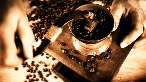 Barista grinding roasted coffee beans in old grinder mill. Food background. 4K Stock Footage