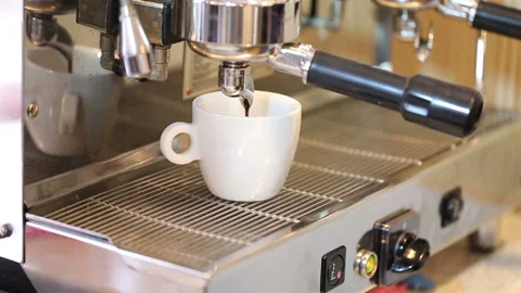 Barista hand presses the start button, the coffee flows into the white cup Stock Footage 96444507