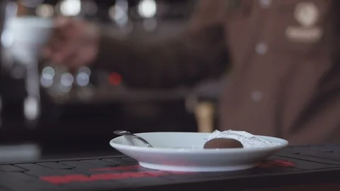 The barista with the help of serves on the bar counter a cup of coffee in the Stock Footage 104105982