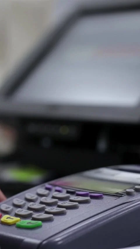 Barista holding a POS terminal while customer making a payment with a Stock Footage 348740124