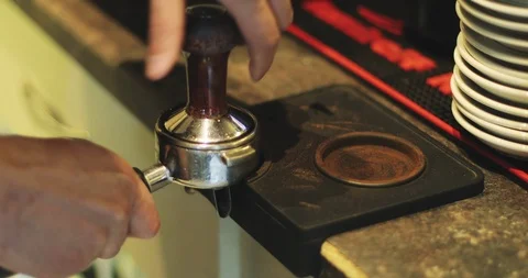 Barista is loading ground coffee in a coffee machine, clamping by press. Stock Footage 94362442