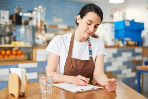 Barista makes notes in the notepad about the menu Stock Photos