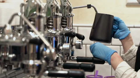 Barista is making coffee in coffee machine using protective gloves and a mask. Stock Footage 142012186
