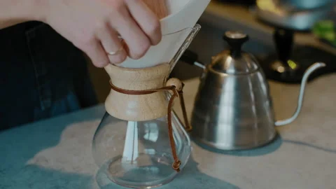 Barista making  Filter coffee by spilling hot water through a layer of coffee Stock Footage 137954808
