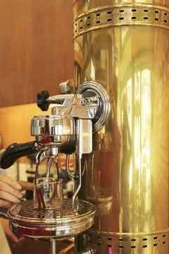 Barista making fresh espresso using a vintage manual lever coffee machine Stock Photos