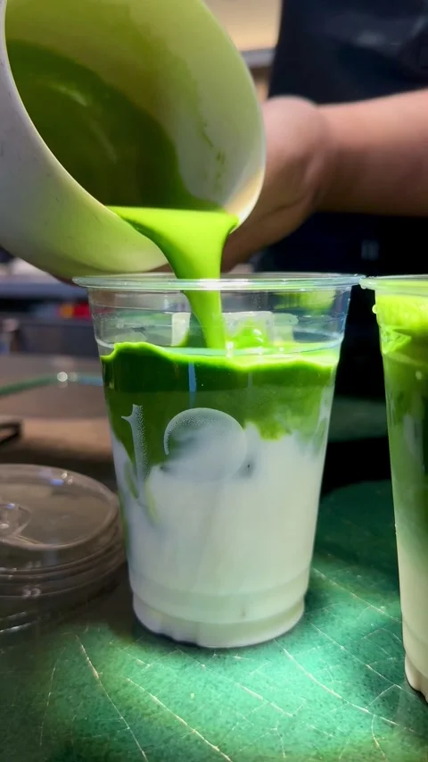 Barista making an iced matcha latte at a fashionable cafe in New York City Stock Footage 319968449