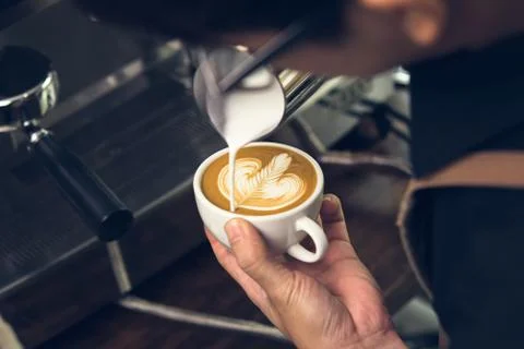 Barista making Rosetta shape latte art coffee Stock Photos