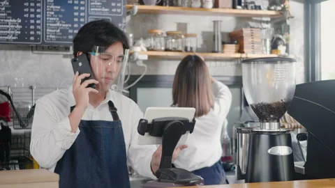 Barista man coffee maker receive phone call and record pre order to computer in Video stock 157410014