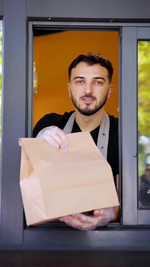 Barista man makes takeaway coffee for a woman customer which pays by contactless Stock Footage 280386545