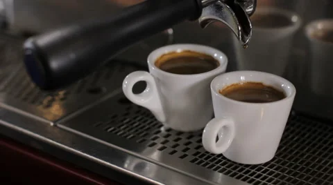 Barista picks up two cups of fresh made espresso. Close up Video stock 63990337