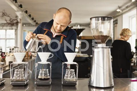 Barista Pouring Boiling Water Into Coffee Filters
