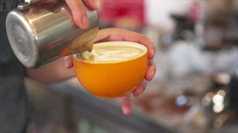 Barista pouring milk into coffee creating latte art in cup. Видео 332893005